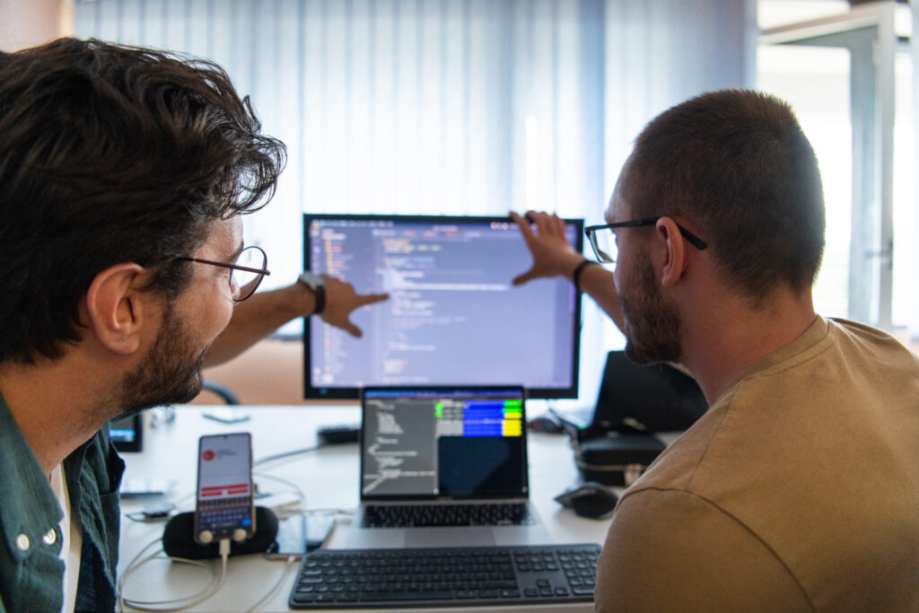 programmers engrossed in deep collaboration, diligently working together to solve complex problems and develop innovative mobile applications with seamless functionality.