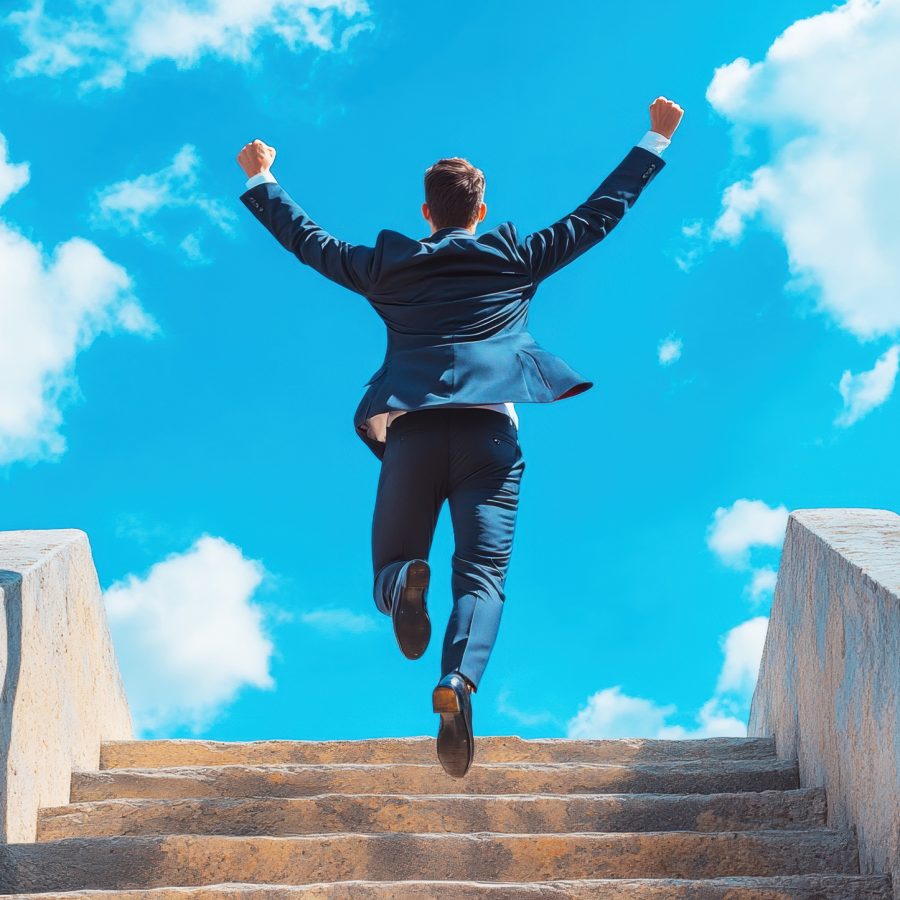 man in suit celebrates success while running up outdoor stairs under blue sky with clouds